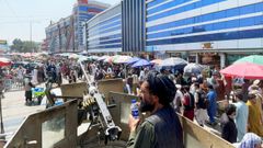 Un talib�n fuertemente armado vigila a la multitud ante un mercado de cambio de divisas en Kabul.