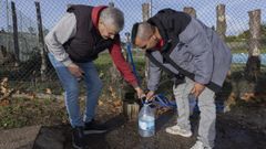 Dos vecinos de la urbanizaci�n privada de monte Xalo llenan una garrafa de agua de un manantial pr�ximo al campo de f�tbol de O Castelo.