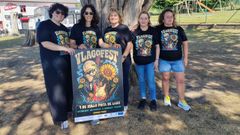 Las organizadoras del V LagoFest posan junto el cartel de esta edici&oacute;n.
