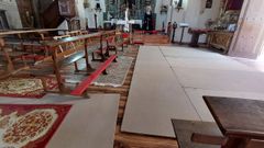 Tablones de aglomerado en el suelo destrozado de la iglesia