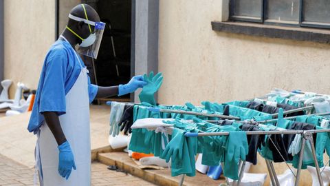 Un sanitario recoge equipo de protecci&oacute;n desinfectado en Uganda