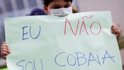Un ni�o sostiene una pancarta en una manifestaci�n antivacunas en Brasilia