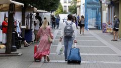 Una pareja abandona este domingo el centro de Ribadeo con sus maletas