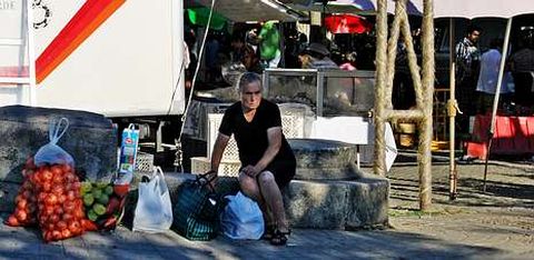 Una mujer regresa de hacer la compra en el mercado de Barcelos, donde los agricultores de la comarca ofrecen sus productos.