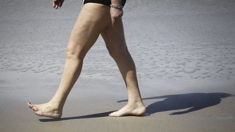 Ba�ista en la playa del Orzan caminando descalzos