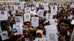 Familiares de las v�ctimas del derrumbe muestran fotograf�as para encontrarlos.