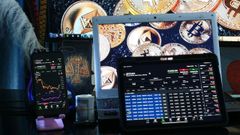 Pantallas de m&oacute;vil y ordenador con cotizaciones de criptomonedas.