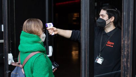 Un trabajador de la sala Apolo, de Barcelona, toma la temperatura a una mujer antes de realizarse un test de ant�genos r�pido para poder acudir al concierto masivo de Love of Lesbian el 27 de febrero