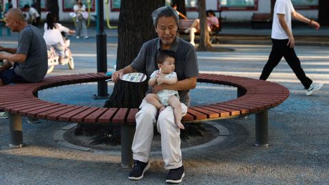 Imagen de archivo de un hombre sujetando a un ni�o peque�o en Beijing.