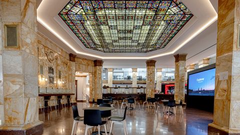 La antigua oficina principal del Pastor situada en la planta baja se transform� en un Work Caf� manteniendo elementos originales como�la c�pula de vidrieras, los elementos de forja, los capiteles y los pavimentos y techos originales.