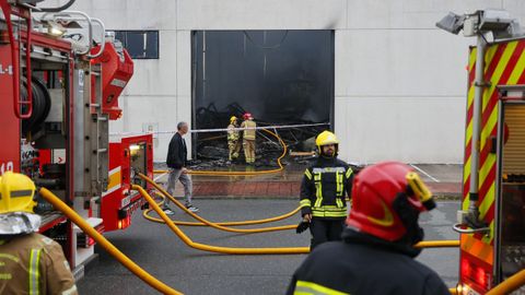 Los bomberos comarcales actuando en el incendio que arras� la nave de Trison en Sada