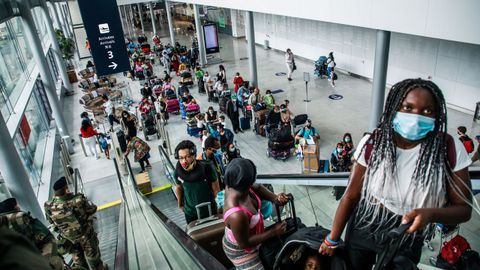  Pasajeros ataviados con m�scaras sanitarias suben por una escalera mec�nica del Aeropuerto de Orly, cerca de Par�s (Francia)