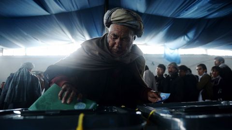 Un hombre deposita su voto en Kabul