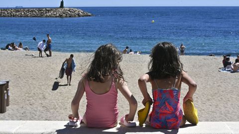 Dos ni�as sentadas en una playa.