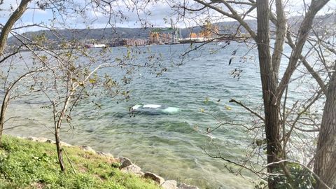 Un coche metido en el agua de la playa de Caranza en la ma�ana de este s�bado, robado la noche anterior.
