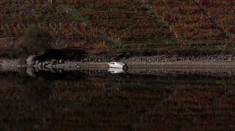 Una lancha amarrada en la orilla chantadina del embalse de Os Peares, y su reflejo en el agua del Mio