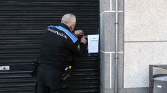 Un agente de la Polic�a Local colocaba ayer por la tarde el cartel que advierte del precinto del bajo