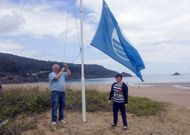 Jes�s Novo izando a finales de junio una de las banderas azules en la playa vicedense de Abrela.