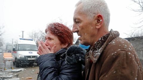 Una pareja ucraniana ante su casa destrozada por la guerra en Donetsk