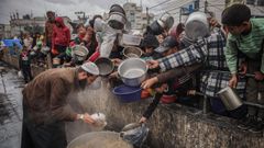 Varios palestinos se apian para conseguir un poco de comida en Rafah.
