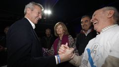 Rueda, con su madre al lado, saluda a un afiliado en el mitin de Ribadeo.