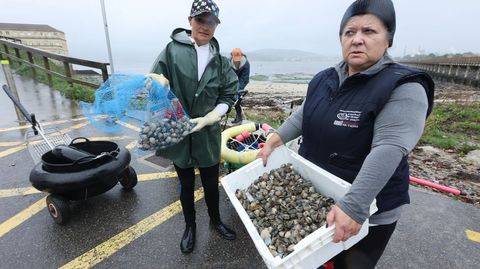 Mariscadoras de la ra de Pontevedra mostrando la gran cantidad de almeja que capturaron muerta y la escasa que lograron sacar viva.