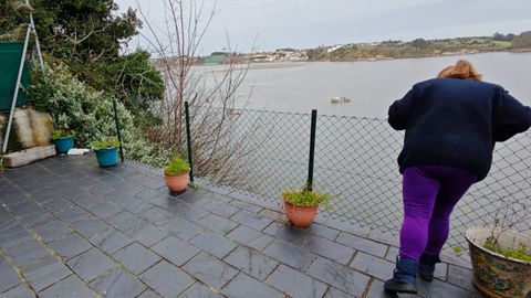 Una vecina se asoma a la terraza que, en parte, ha quedado sobre el aire tras el desprendimiento