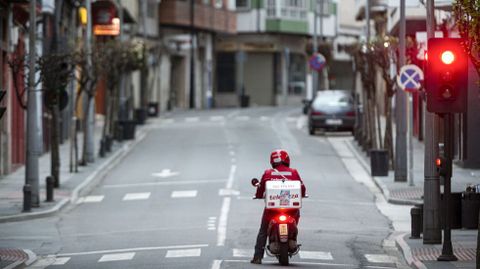 Un repartidor en un semforo en rojo