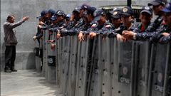 Un hombre se dirige a los agentes del Sebin apostados en el exterior del Palacio Legislativo de Caracas