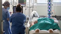 Dos enfermeras atienden a un paciente en la uci del Hospital Reina Sof�a de Murcia