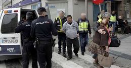 Agentes de la Polic�a Nacional trasladan a uno de los detenidos durante los registros.