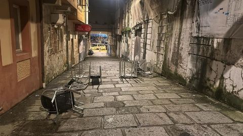 Sillas de una terraza movidas por el viento en una calle de Ferrol Vello.