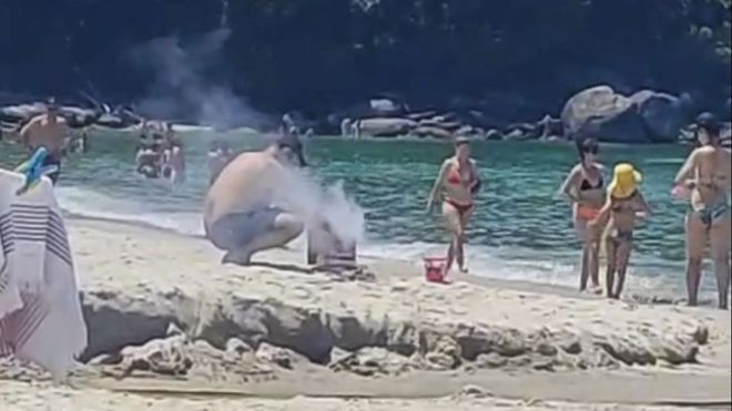 Un baista asa en la playa de Lapamn