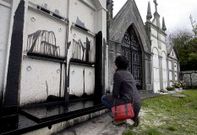 Una mujer observa las manchas de aceite en los seis nichos del pante�n.