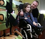 Candela, con su padre, en su casa, donde no faltan aparatos para intentar que se ponga en pie. 