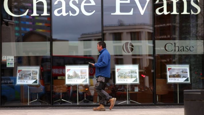 Un viandante camina ante el escaparate de una agencia inmobiliaria en Londres.