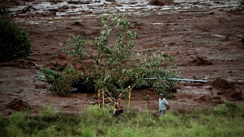 - Un grupo de personas observan los efectos del desastre 