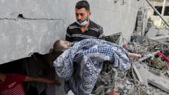 Un hombre, portando el cad�ver de una ni�a fallecida en el bombardeo israel� de su casa en Nuseirat, en la Franja