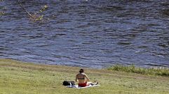 Una mujer toma el sol el pasado mes de marzo a orillas del r�o Mi�o en Lugo