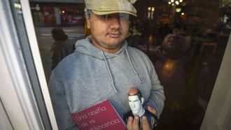 Lucas Oubi�a Fojo, con su libro y una figura, tras una cristalera del Caf� Moderno, en Pontevedra