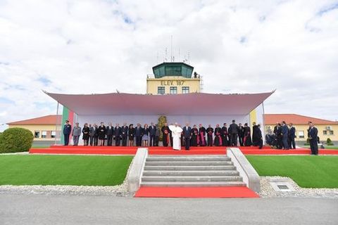 Fotografa facilitada por el peridico L'Osservatore Romano que muestra al papa Francisco (c) posando para una foto de familia durante una ceremonia de bienvenida en la base area del Monte Real en Leiria