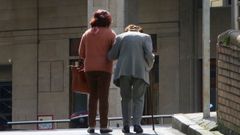 Una se�ora mayor sale a la calle acompa�ada de su cuidadora