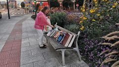 En la imagen, una vecina de la zona escogiendo un libro en el banco.