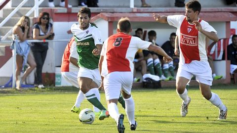 Juampa se abre paso entre dos jugadores de O Val