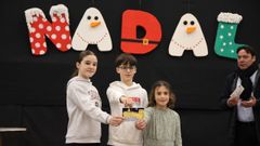 Los tres ganadores con una de las postales
