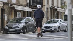Imagen del pasado mes de agosto de un usuario de patinete con casco en una calle de Santiago.