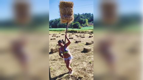 Fotograf�a de Cristina Boga Sanmart�n en la que sale ella misma durante una jornada veraniega mientras carga la hierba seca en el remolque de un tractor. La imagen fue presentada al concurso D�a da Muller Rural de Negreira y result� la vencedora del certamen municipal con el que se buscaba �reivindicar o papel da muller, reco�ecendo a s�a contribuci�n na promoci�n do desenvolvemento agr�cola e rural, na mellora da seguridade alimentaria e a erradicaci�n da pobreza no rural�. El premio para la ganadora es un vale dotado con 100 euros para consumir en el comercio local de Negreira.
