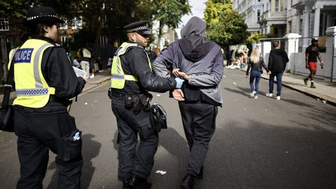 Dos polic�as detienen a una persona durante el carnaval de Notting HIll