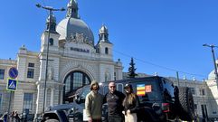 Milena Vallo y V�ctor Vidal junto con un responsable del voluntariado de Le�polis (centro) ante la estaci�n de tren de la localidad ucraniana a la que llegn cada d�a con su Jeep cargado de alimentos