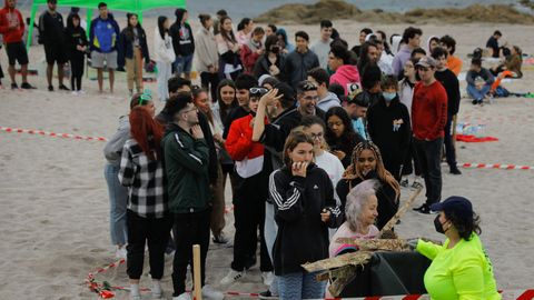 Cola para conseguir madera en la playa de Riazor